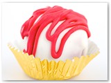 Sweet Sushi Strawberry Cheesecake Cake Ball- Strawberry cake mixed with our signature cream cheese icing, dipped in white chocolate and drizzled with red chocolate.